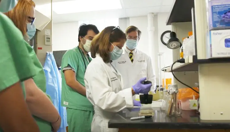 Infectious Disease fellows in the lab pipetting with an attending physician.