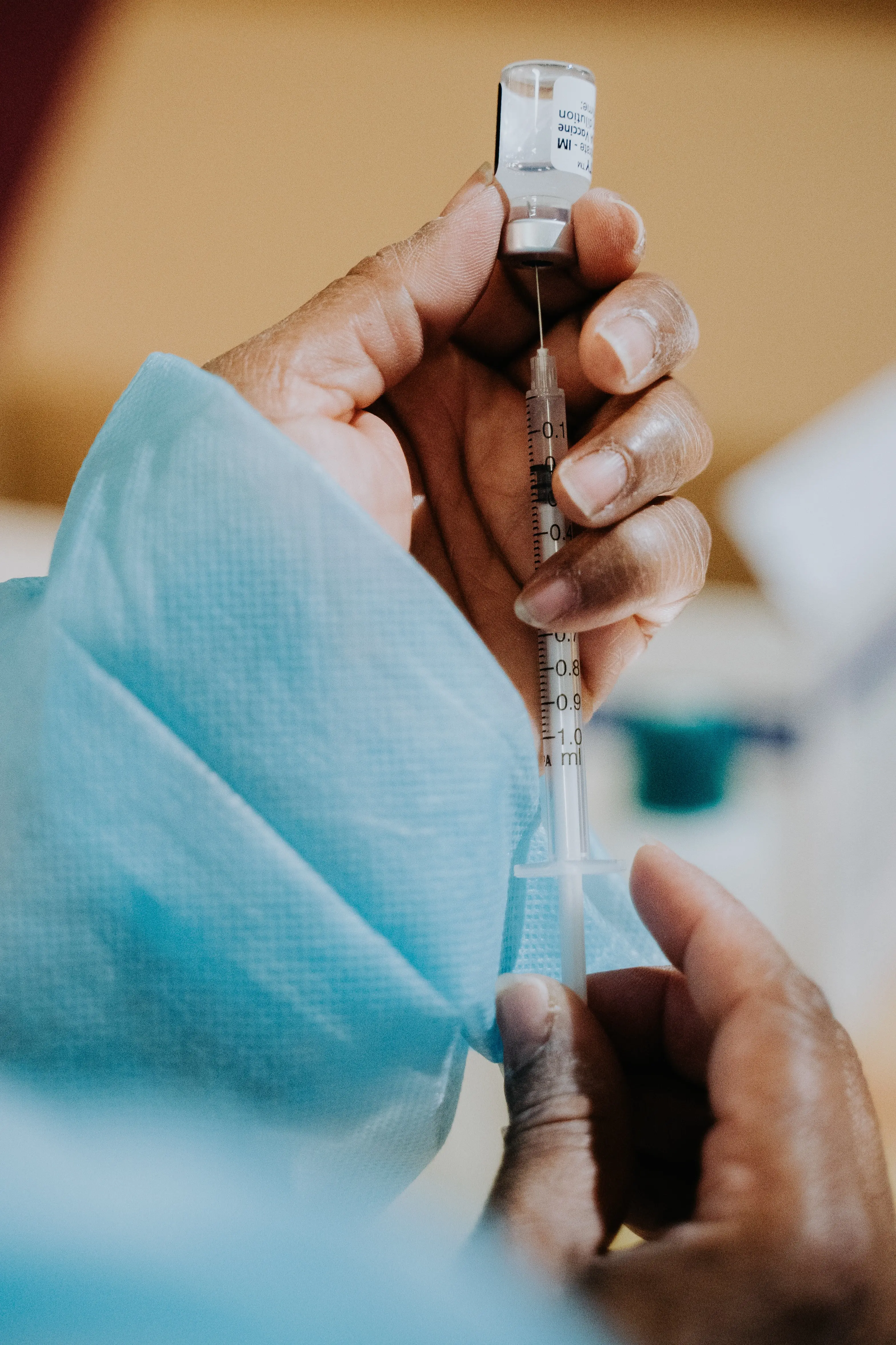 Vaccine from a vial being drawn into a syringe.